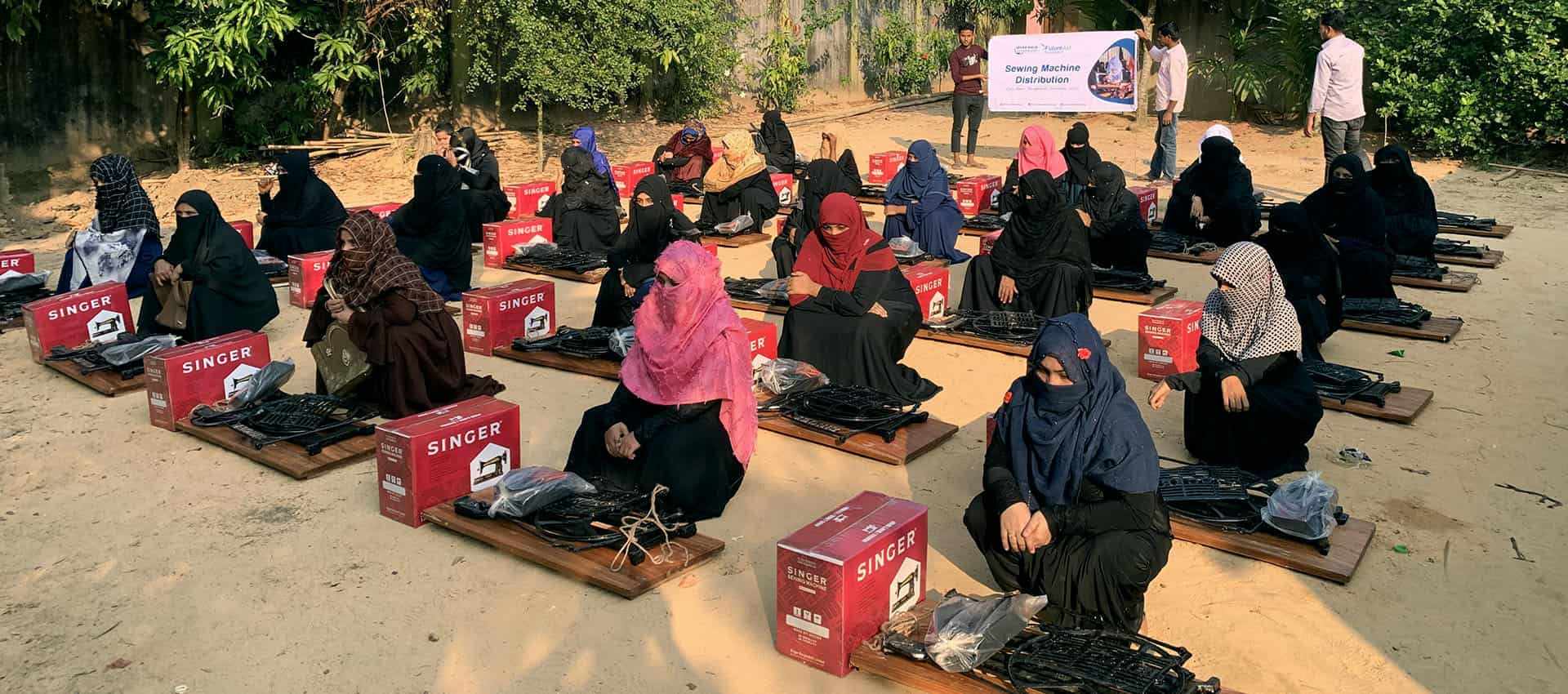 Women receiving sewing machines at a Shonirvor Samaj sewing machine distribution