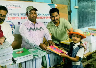 A young pupil receiving exercise books at a School Kits Distribution 2020 table