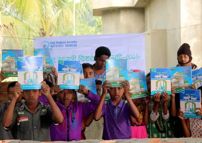 Children holding up their new textbooks at a 2018 education materials distribution