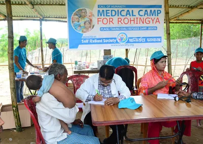 A doctor examining patients at a medical camp for Rohingya refugees