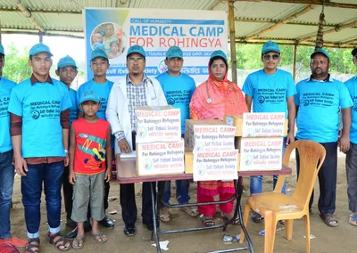 Volunteers and medical staff in front of the Medical Camp for Rohingya banner