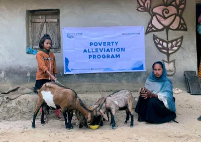 A woman and a girl with goats given through the Poverty Alleviation Program