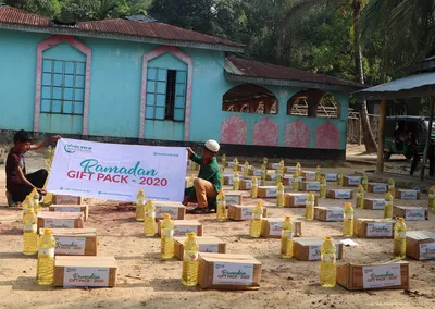 Volunteers laying out Ramadan Gift Pack 2020 boxes and bottles of cooking oil