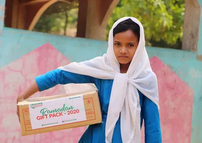 A girl carrying a Ramadan Gift Pack 2020 box