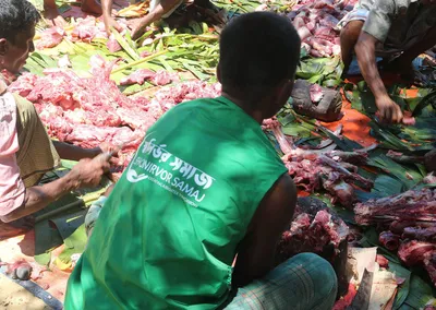 A volunteer cutting Qurbani meat into portions