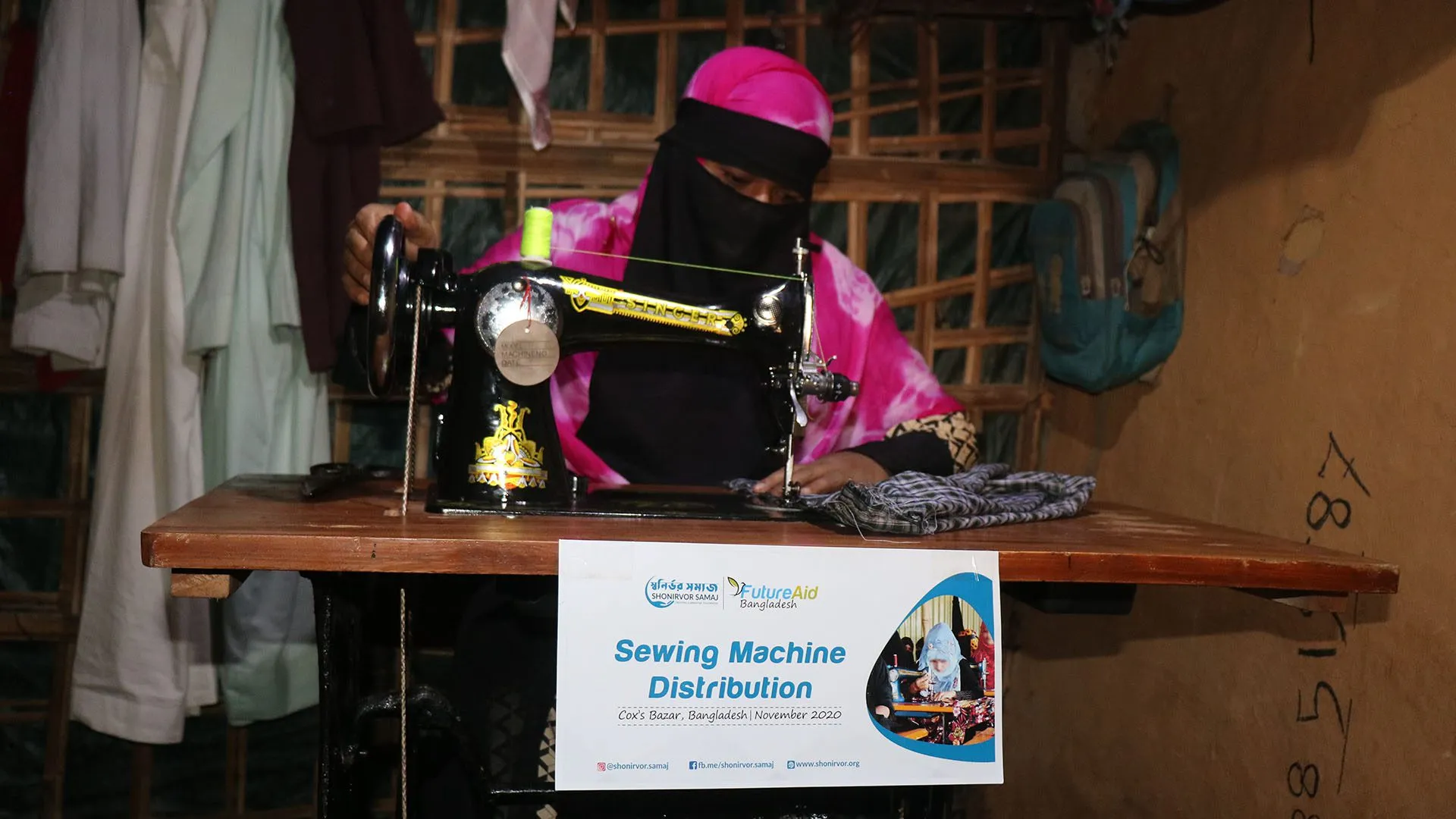 A woman sewing at a sewing machine handed out at a sewing machine distribution